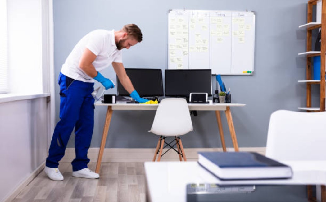 Cleaning crew member performing office desk maintenance