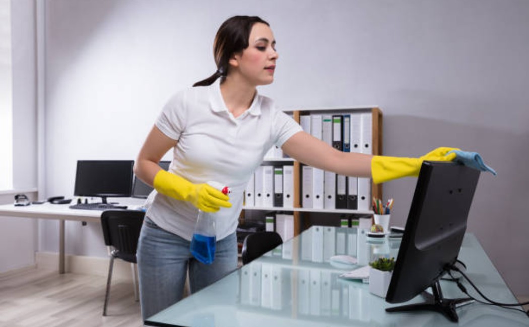 Office cleaning: janitor dusting computer equipment