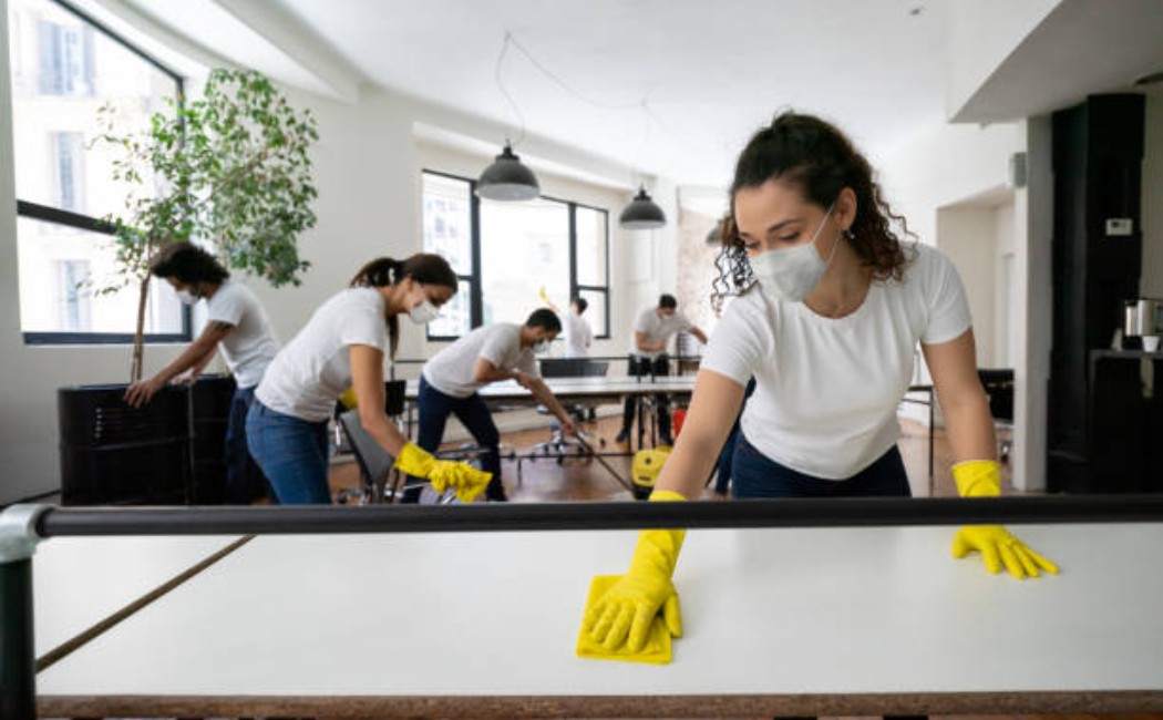 Professional cleaners are cleaning the office, wearing face masks