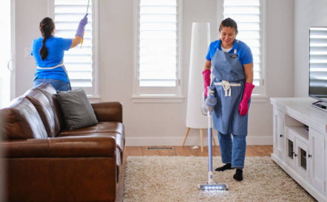 Professional house cleaners working in a living room